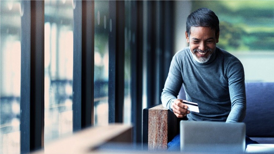 Man in front of the computer about to make an online purchase